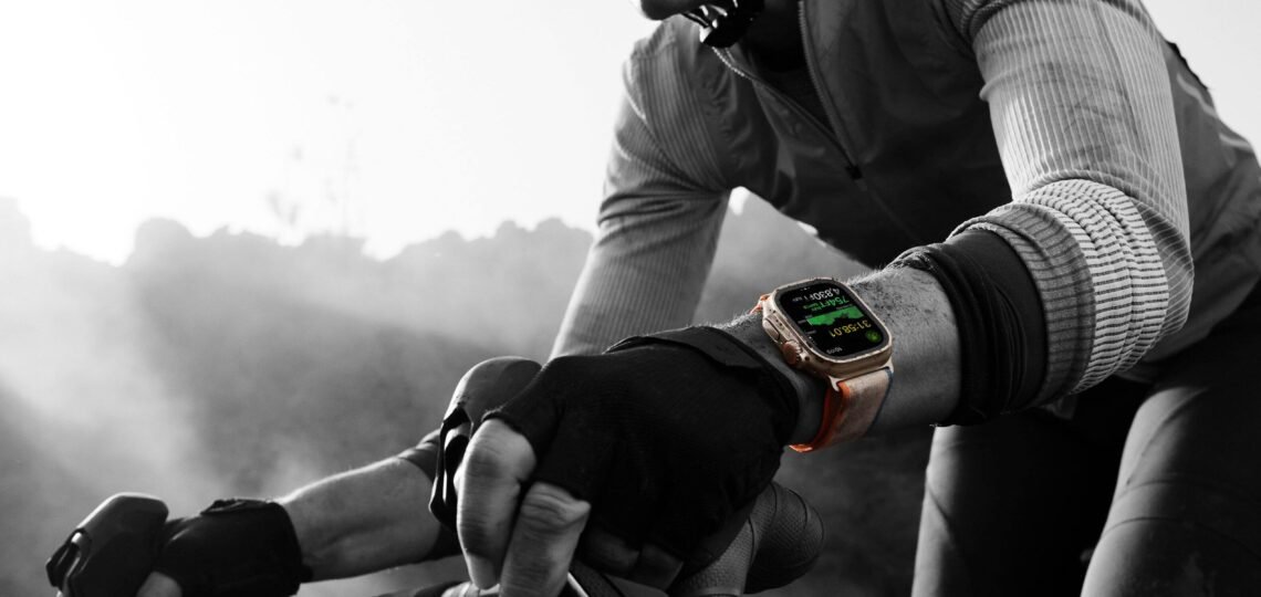 Apple Watch Ultra 2 GPS + Cellular sendo usado por ciclista durante pedal ao ar livre, com dados de velocidade e batimentos exibidos na tela